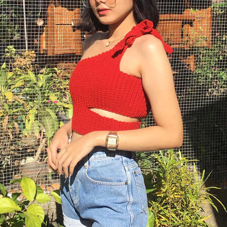 A stylish woman in a handmade cream and brown butterfly crochet halter top, ideal for bohemian summer outfits.